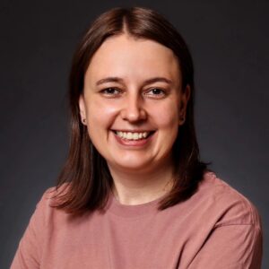 erzählkonstrukt: Das Foto zeigt die Autorin der Webseite. Sie ist eine Frau mittleren Alters und hat schulterlange braune Haare. Sie trägt ein blassrosa Shirt auf dem Bild.